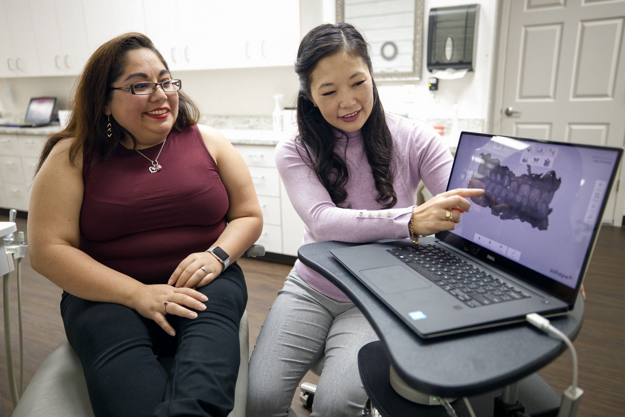 Patient consulting with orthodontist at Texas Family Orthodontics, discussing braces options on laptop in San Antonio clinic.